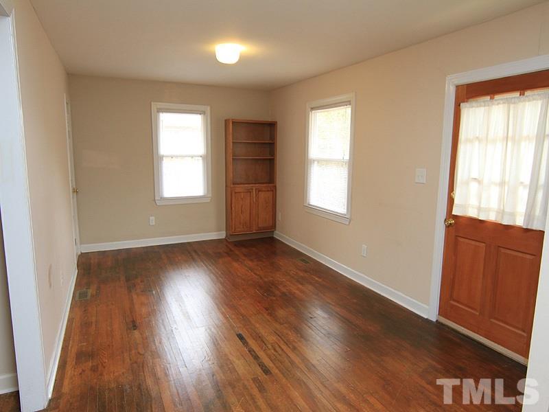 1027 Carpenter Fletcher Road Durham, NC 27713 - Photo 4 of 12 Living room has original hardwood floors, as does the entire home with the exception of bathroom. Built-in bookshelves.