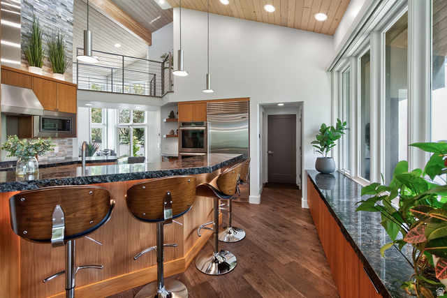 11454 South Oberland Road Sandy, UT 84092 - Photo 20 of 103 Vaulted wood-paneled ceiling with recessed lighting, wood-finish flooring, stainless steel appliances, large windows, and a stone-clad accent wall