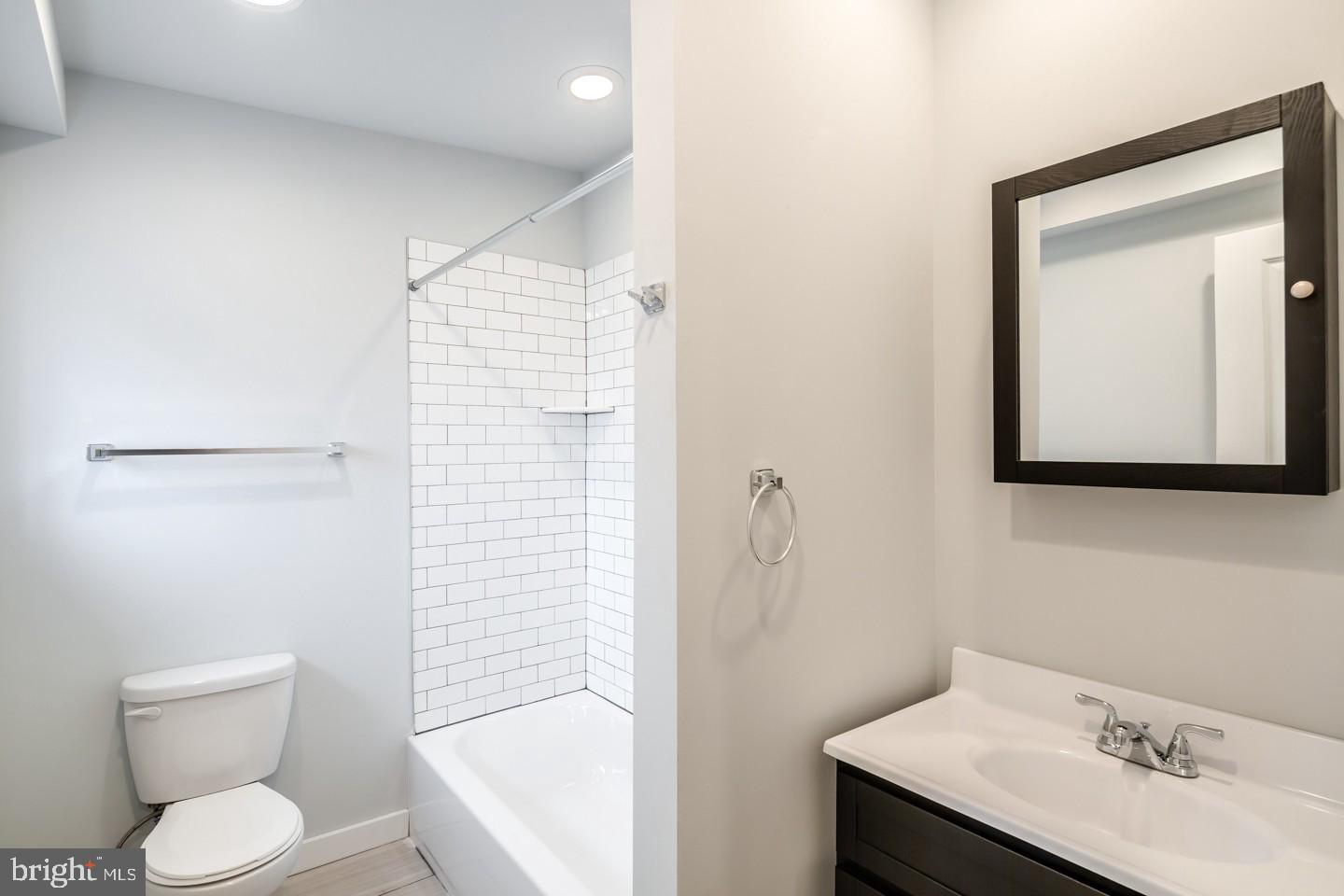 2221 South Broad Street, Unit 2R Philadelphia, PA 19148 - Photo 6 of 7 a bathroom with a toilet sink vanity and mirror