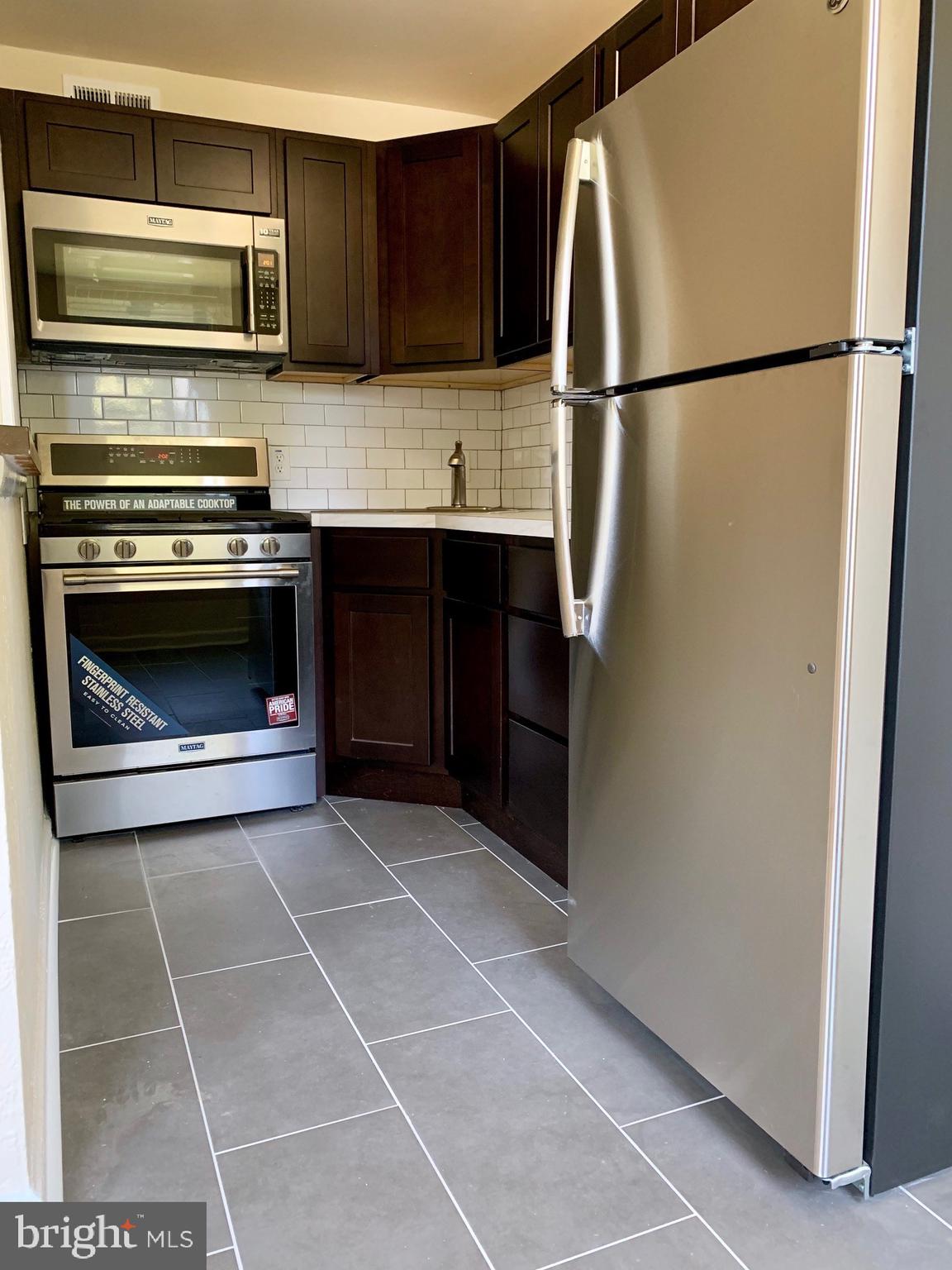 2221 South Broad Street, Unit 2R Philadelphia, PA 19148 - Photo 7 of 7 a kitchen with a refrigerator stove and microwave