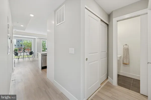 a view of a hallway with wooden floor and a bathroom