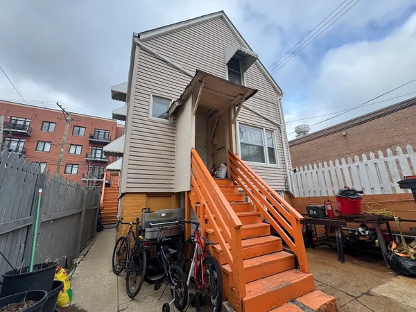 a backyard of a house with barbeque oven table and chairs