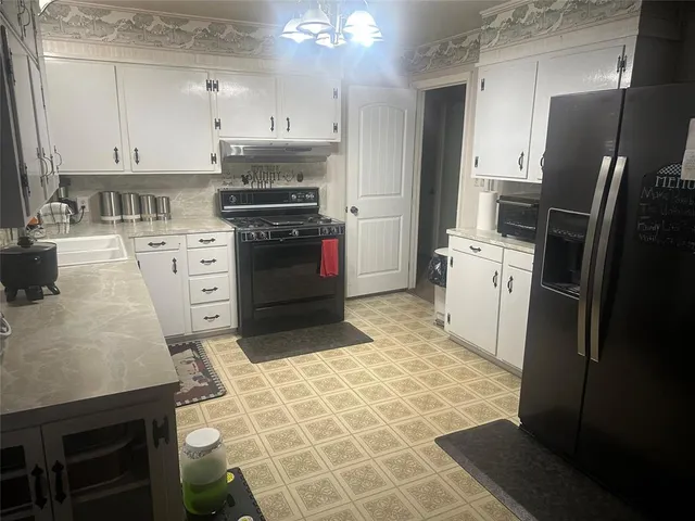 a kitchen with granite countertop a refrigerator stove and sink