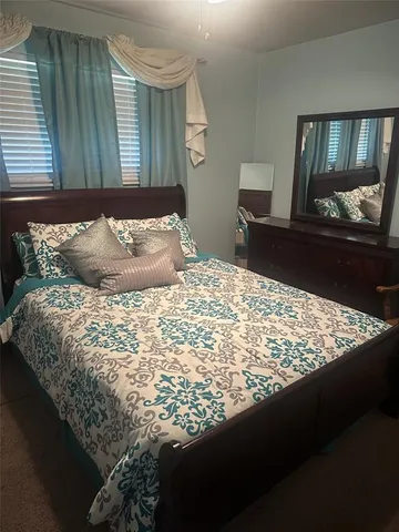 a bed sitting in a bedroom next to a window