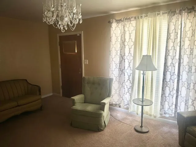 a living room with furniture and a chandelier