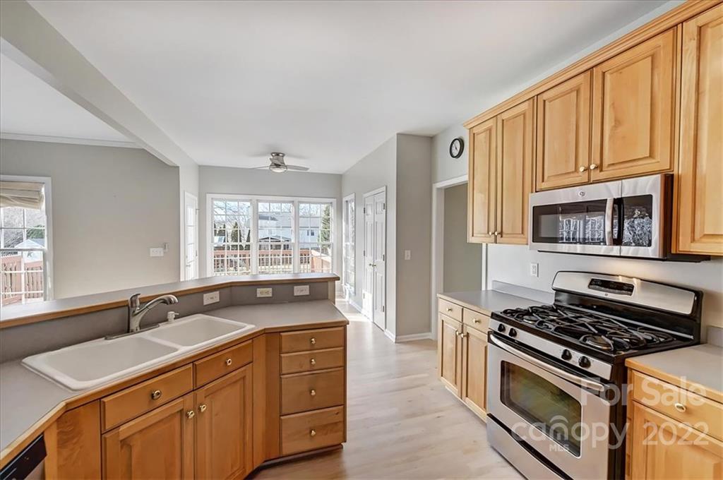 10409 Friarsgate Road Huntersville, NC 28078 - Photo 11 of 30 a kitchen with wooden cabinets stove and sink