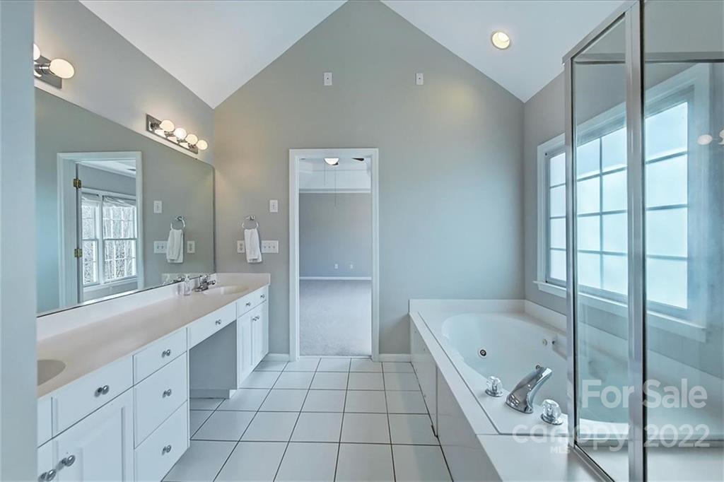 10409 Friarsgate Road Huntersville, NC 28078 - Photo 17 of 30 a large bathroom with a glass door shower a sink and mirror
