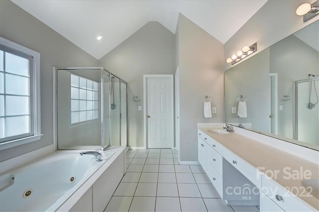 10409 Friarsgate Road Huntersville, NC 28078 - Photo 18 of 30 a spacious bathroom with a tub sink shower and mirror