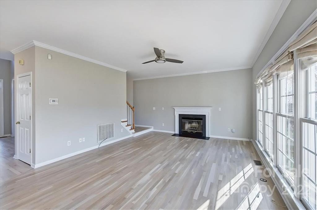 10409 Friarsgate Road Huntersville, NC 28078 - Photo 8 of 30 wooden floor in an empty room with a fireplace