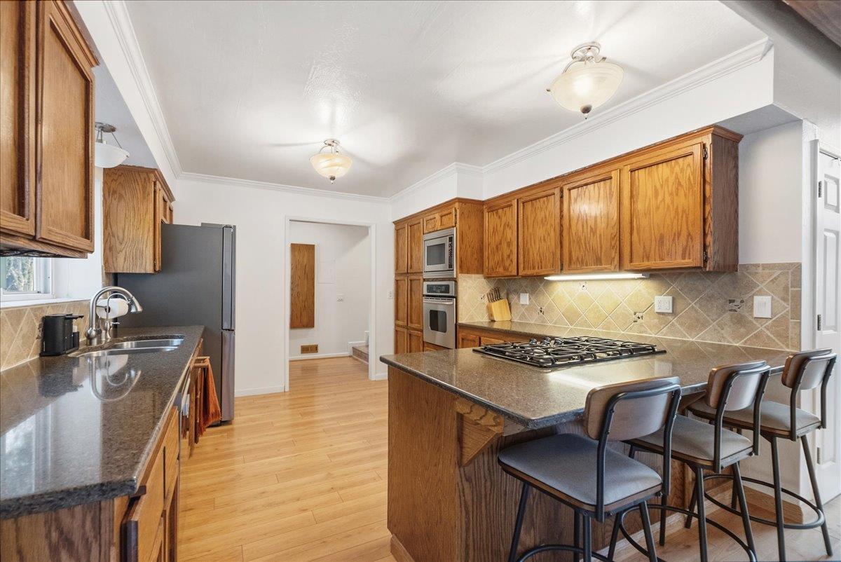 5621 Saw Mill Road Placerville, CA 95667 - Photo 19 of 75 a kitchen with stainless steel appliances granite countertop a stove top oven a refrigerator a sink and chairs