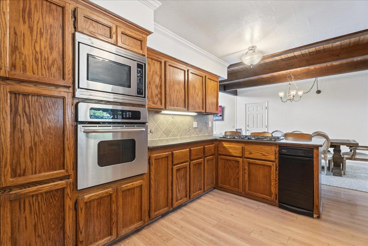 5621 Saw Mill Road Placerville, CA 95667 - Photo 20 of 75 a kitchen with stainless steel appliances granite countertop a stove top oven a sink dishwasher and wooden cabinets with wooden floor