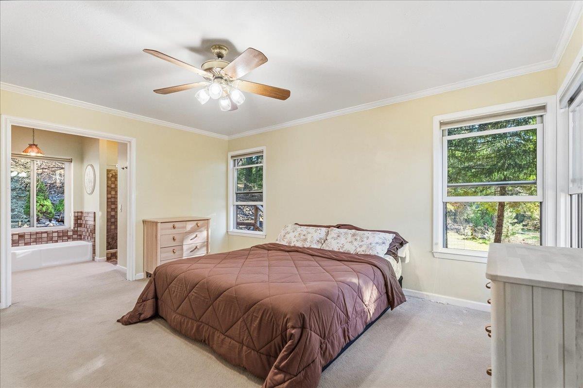 5621 Saw Mill Road Placerville, CA 95667 - Photo 32 of 75 a bedroom with a large bed and a chandelier fan