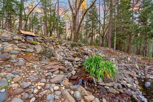 a view of a house with backyard and trees