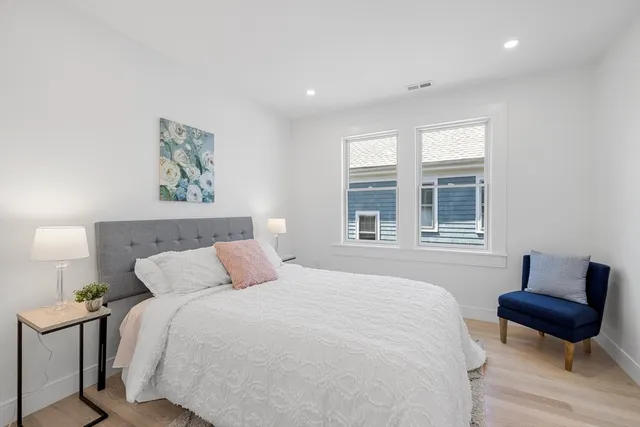 a bedroom with a bed and wooden floor