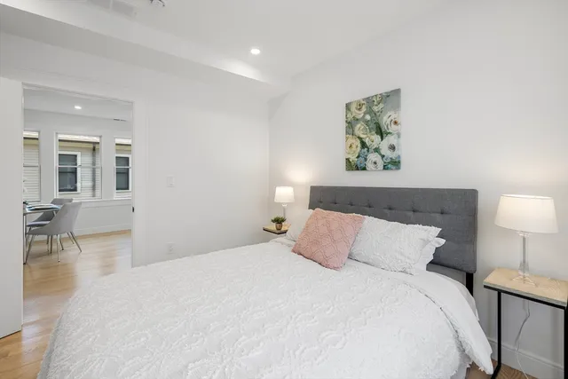 a bedroom with a bed and wooden floor