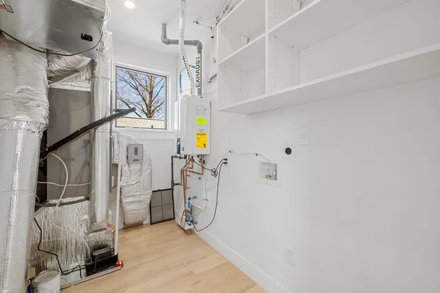 a hallway with white cabinets and wooden floor