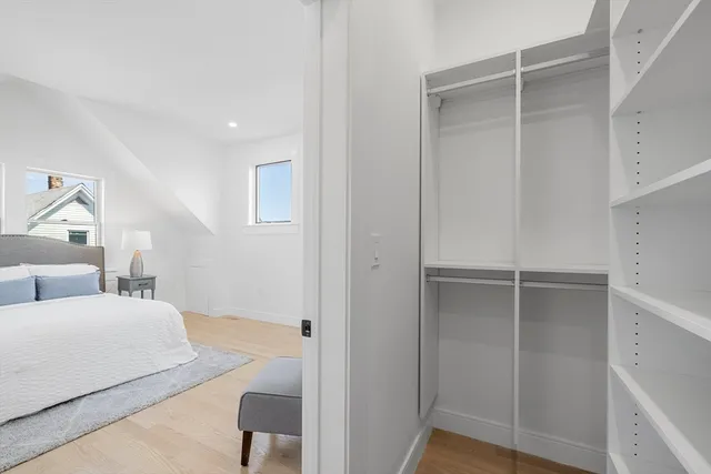 a spacious bedroom with a bed and a chandelier