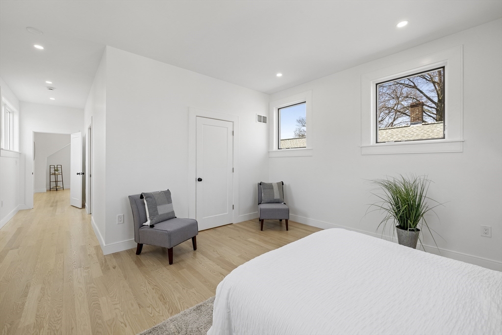 39 Seven Pines Avenue, Unit 39 Cambridge, MA 02140 - Photo 39 of 42 a spacious bedroom with a bed and a chandelier