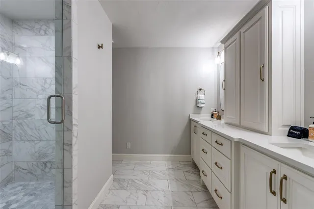 a bathroom with a double vanity sink a mirror and a shower