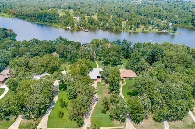 an aerial view of a house with a yard and lake view