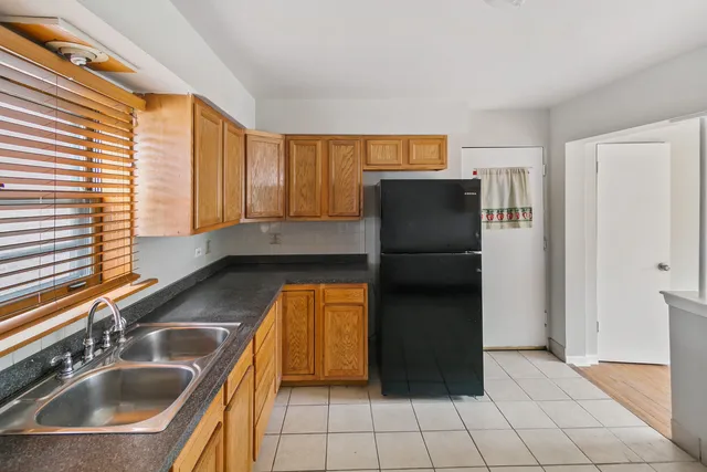 a kitchen with a refrigerator sink and cabinets