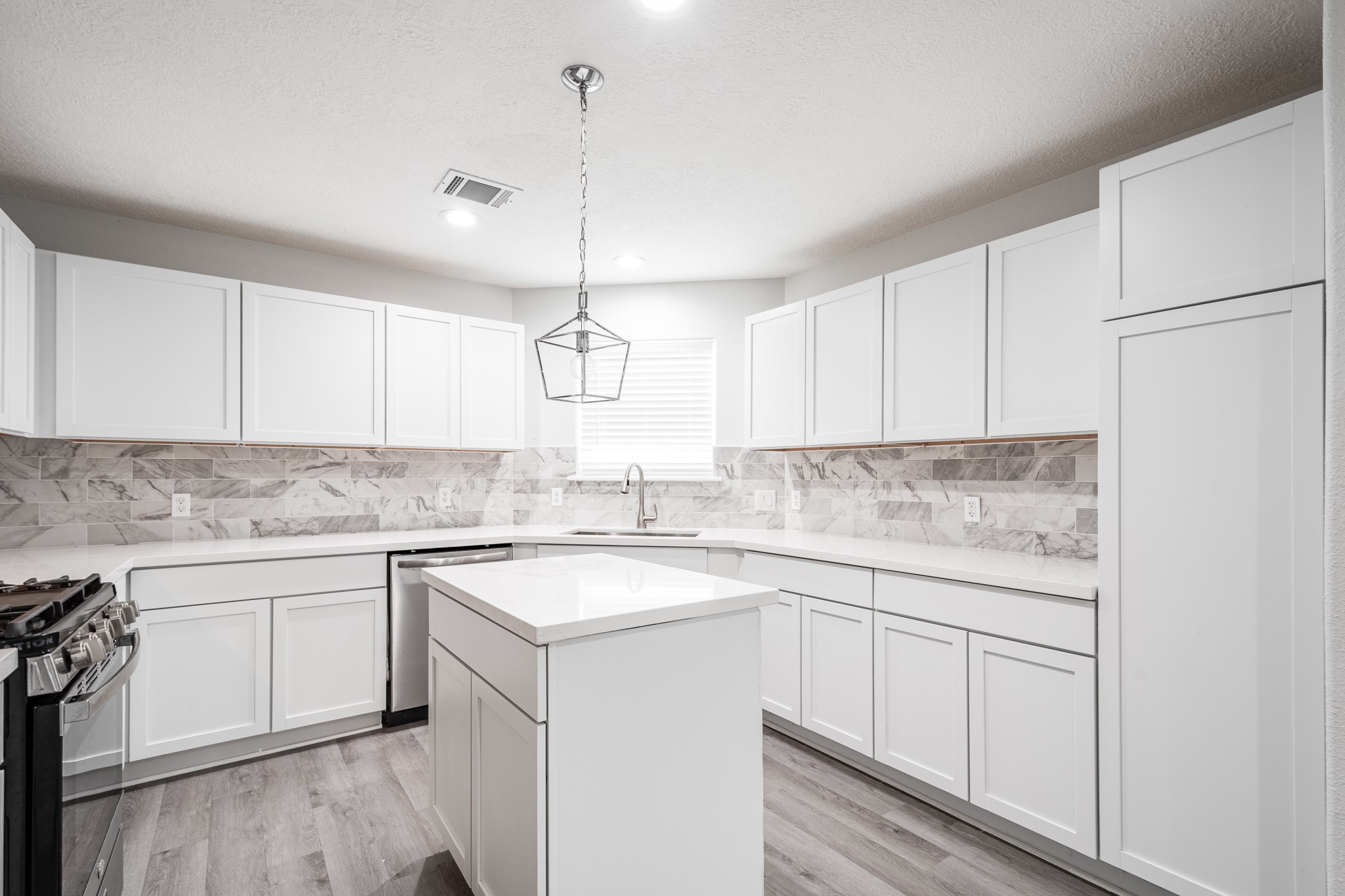 9026 McGallion Road Houston, TX 77022 - Photo 11 of 34 a kitchen with a sink white cabinets and white appliances