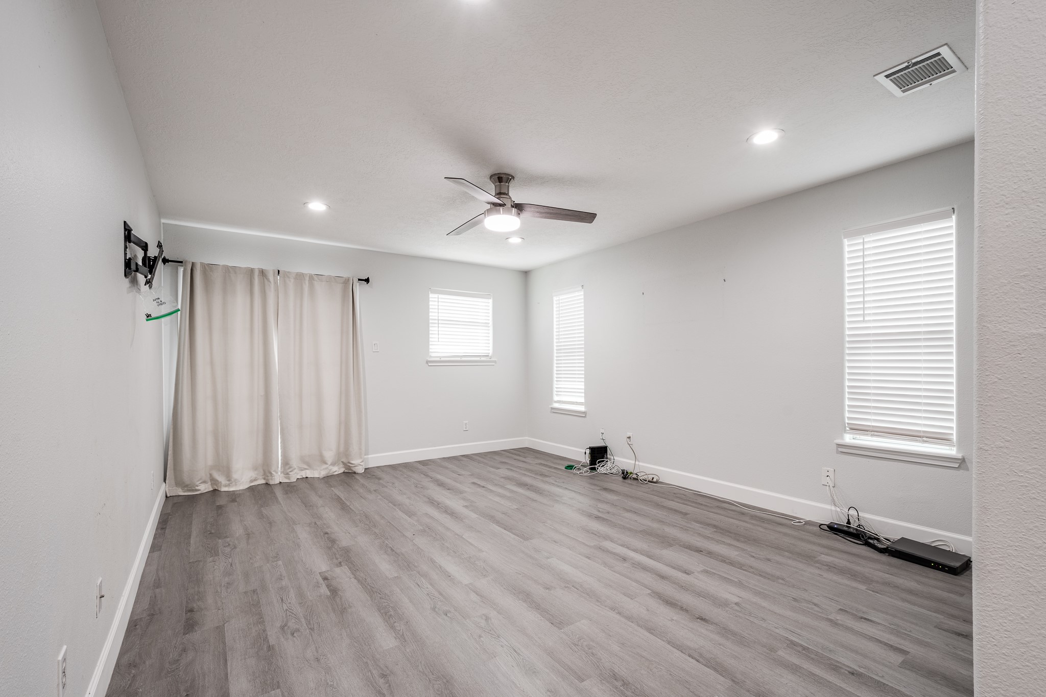 9026 McGallion Road Houston, TX 77022 - Photo 20 of 34 an empty room with wooden floor and windows