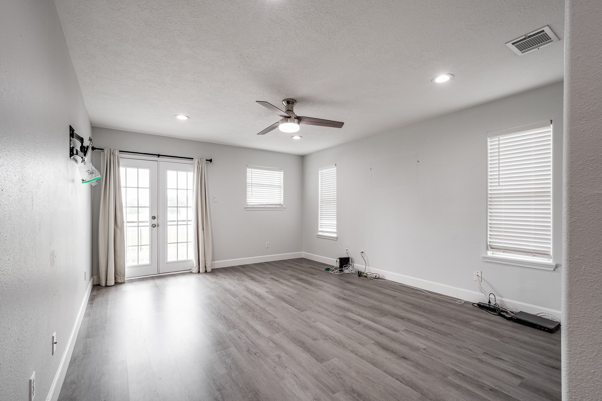 9026 McGallion Road Houston, TX 77022 - Photo 21 of 34 an empty room with wooden floor and windows