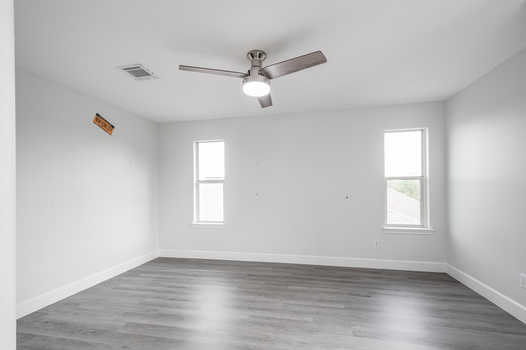 9026 McGallion Road Houston, TX 77022 - Photo 29 of 34 an empty room with wooden floor ceiling fan and windows
