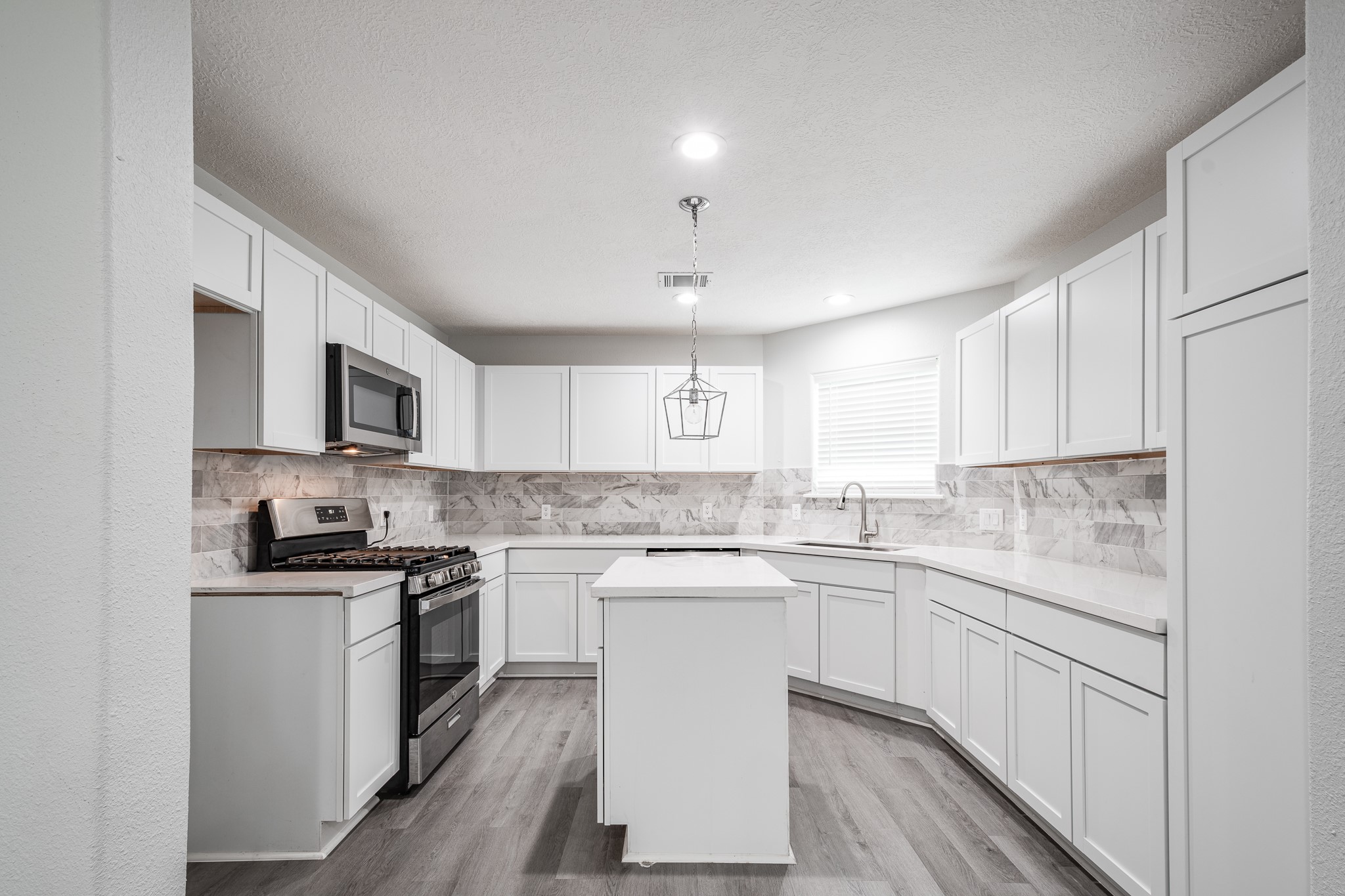 9026 McGallion Road Houston, TX 77022 - Photo 30 of 34 a kitchen with a sink stove cabinets and refrigerator