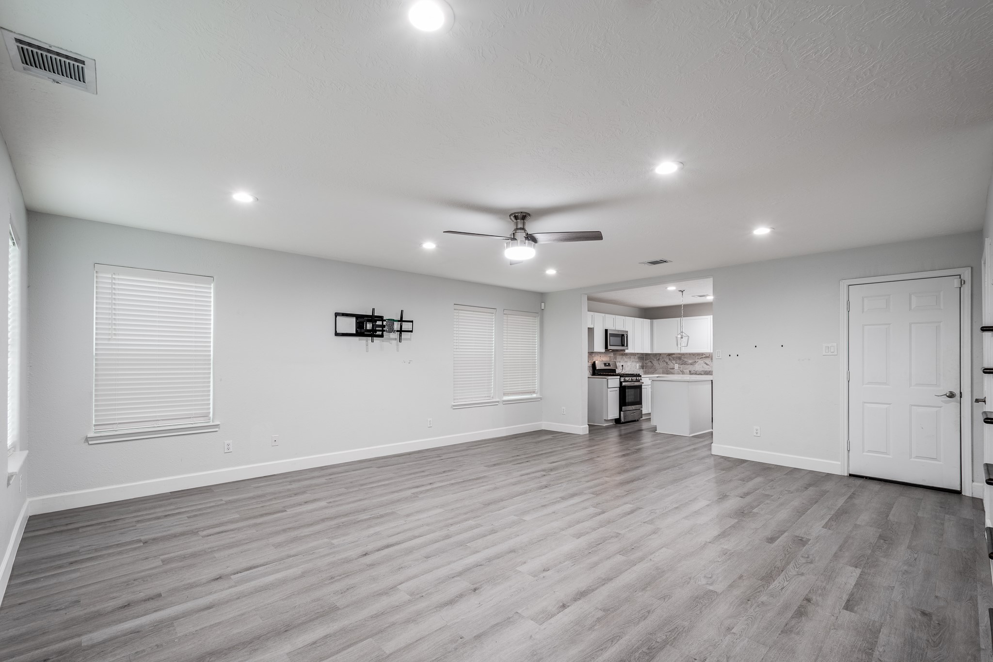 9026 McGallion Road Houston, TX 77022 - Photo 5 of 34 an empty room with wooden floor and windows