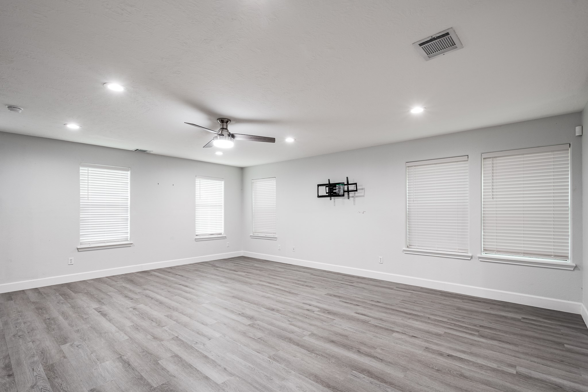 9026 McGallion Road Houston, TX 77022 - Photo 8 of 34 an empty room with wooden floor and windows