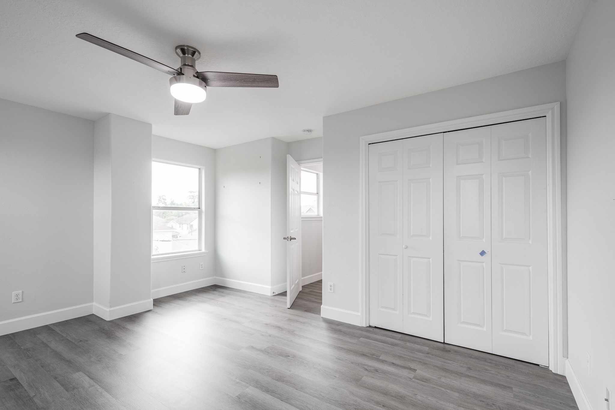 9026 McGallion Road Houston, TX 77022 - Photo 9 of 34 an empty room with wooden floor and windows