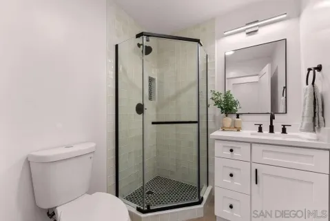 a bathroom with a granite countertop sink toilet and shower