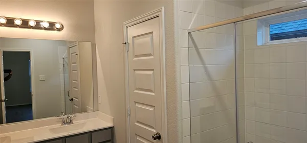 a bathroom with a shower and a sink