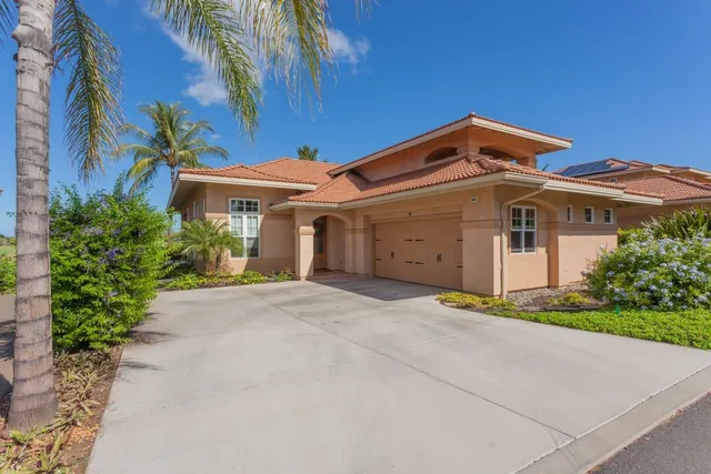 a front view of a house with a yard and a garage