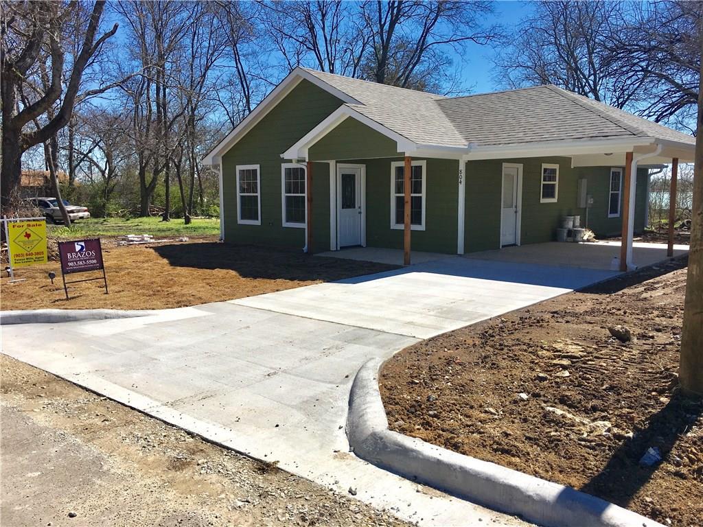 a view of a white house with a large tree in front of it