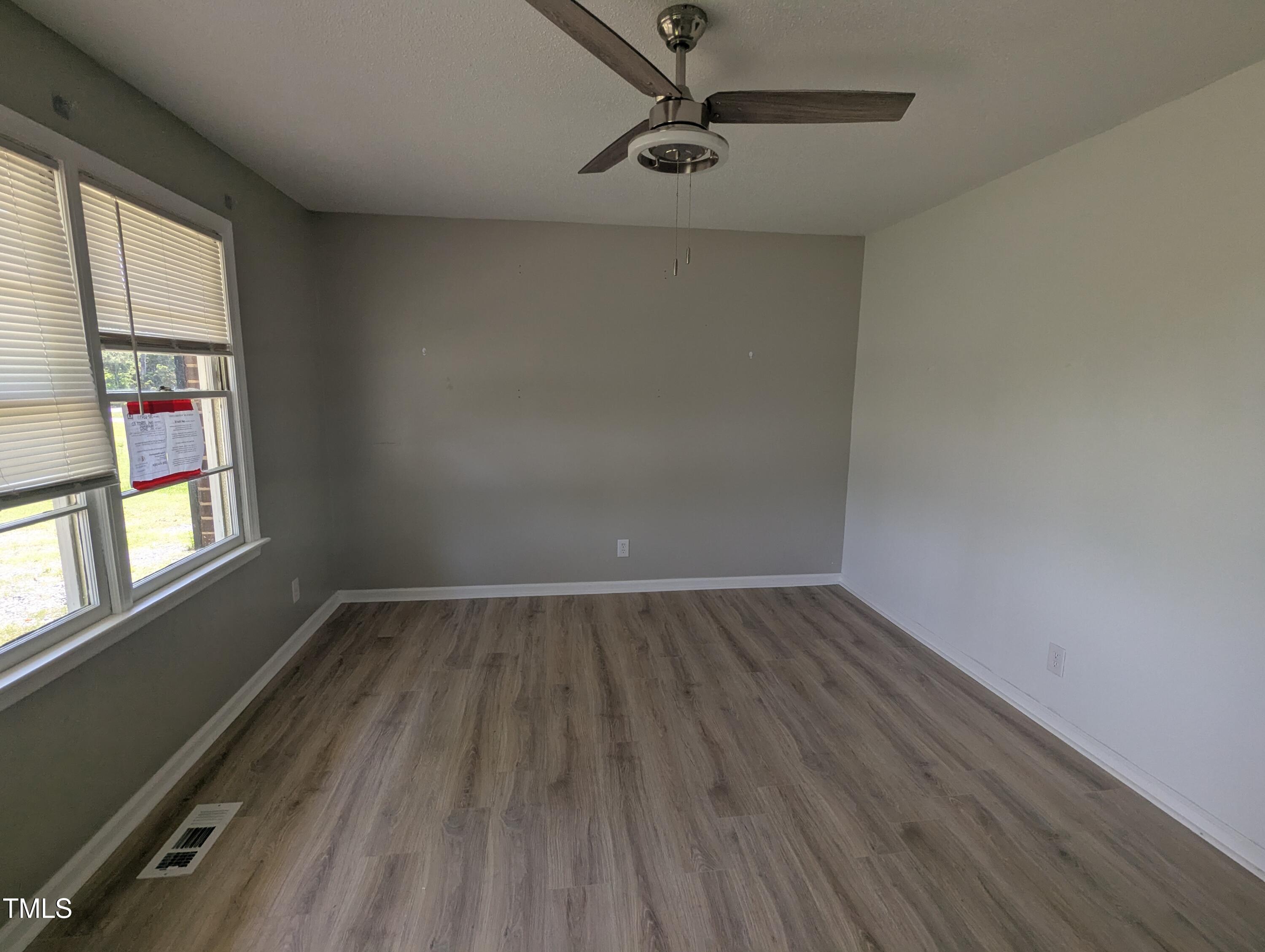 1064 Abbott Road Henderson, NC 27537 - Photo 3 of 9 wooden floor in an empty room with a window