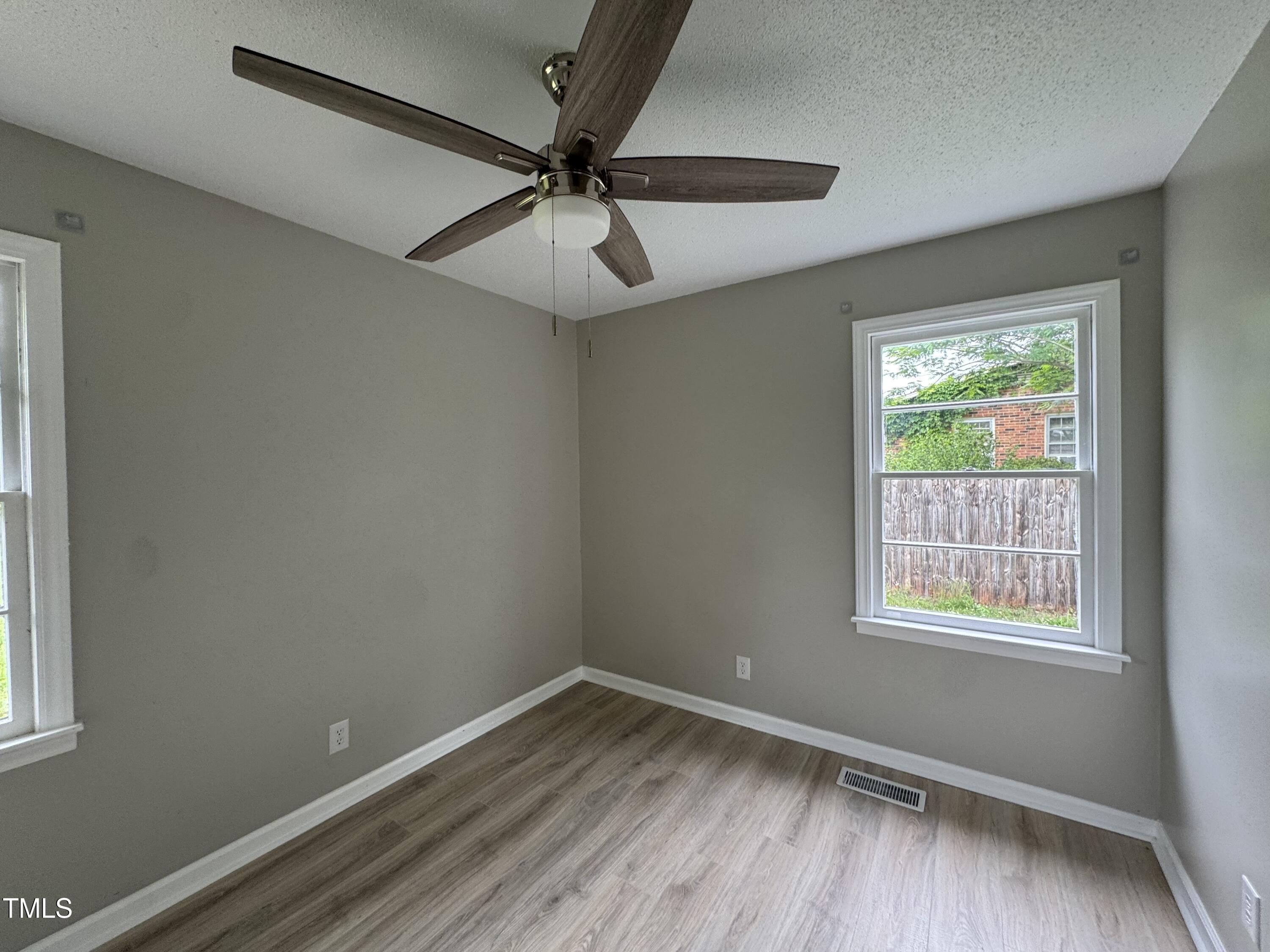 1064 Abbott Road Henderson, NC 27537 - Photo 5 of 9 a view of an empty room with wooden floor and a window