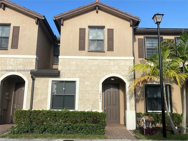 a front view of a house with plants and entryway