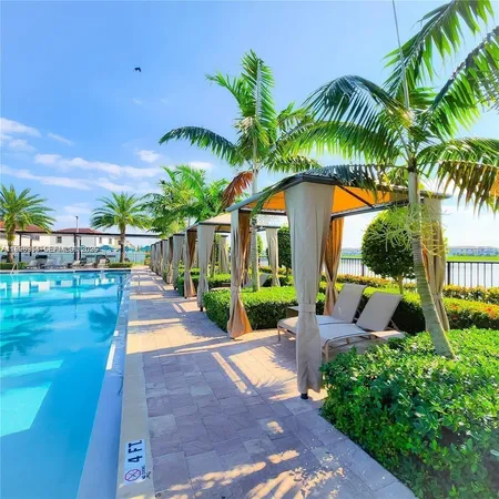 a view of swimming pool with a patio and a garden