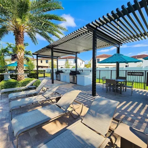 a view of a patio with table and chairs under an umbrella