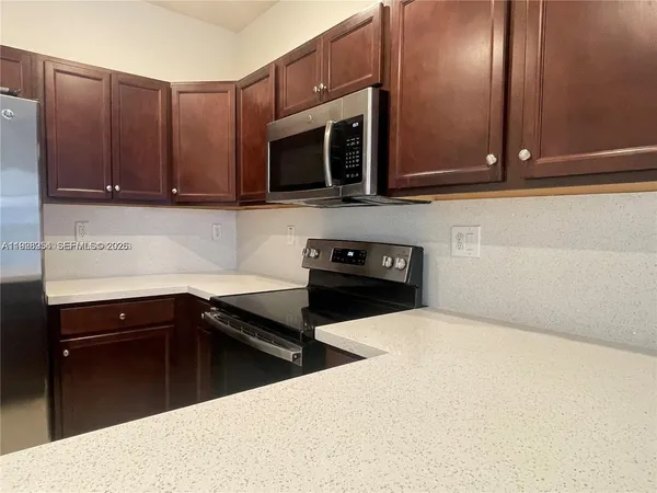 a kitchen with stainless steel appliances a stove microwave and sink