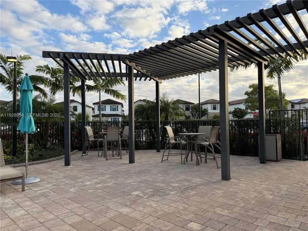 a view of a chairs and table in patio with a barbeque grill