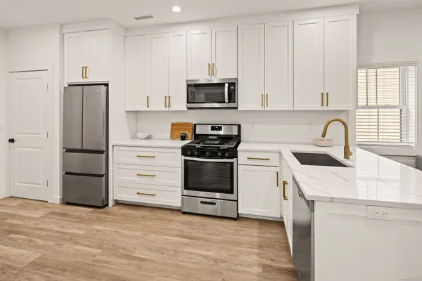 a kitchen with granite countertop a stove and a microwave