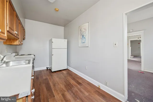 a kitchen with granite countertop cabinets stainless steel appliances a sink and wooden floor