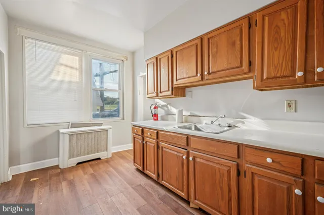 a view of a kitchen with a sink and wooden floor