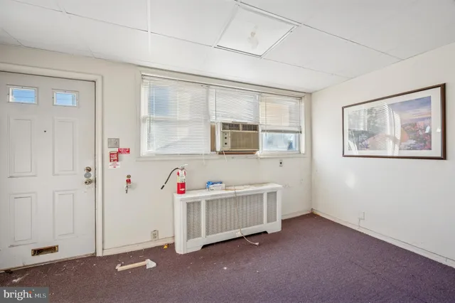 a view of a bedroom with baby crib and windows