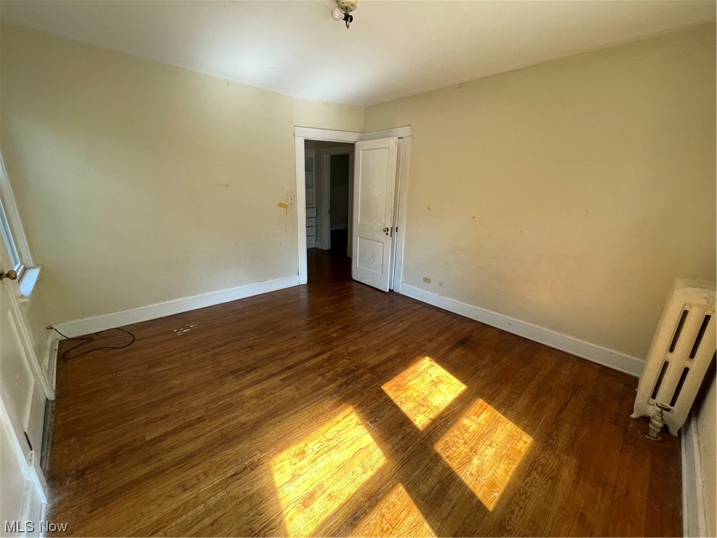 1730 Wood Road Cleveland Heights, OH 44121 - Photo 23 of 34 Hardwood floored empty room with radiator heating unit