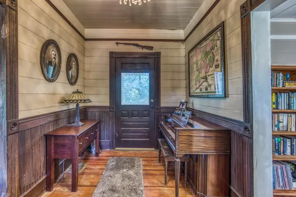 a living room with furniture a bookshelf and a window